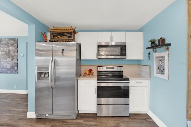 kitchen with stainless steel appliances, white cabinets, dark wood-style flooring, and light countertops