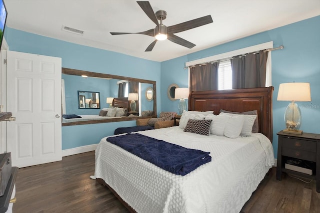 bedroom featuring a ceiling fan, wood finished floors, visible vents, and baseboards