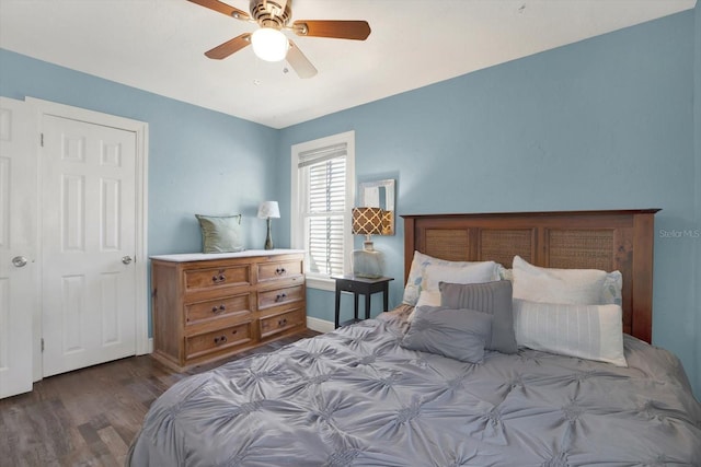 bedroom featuring baseboards, wood finished floors, and a ceiling fan