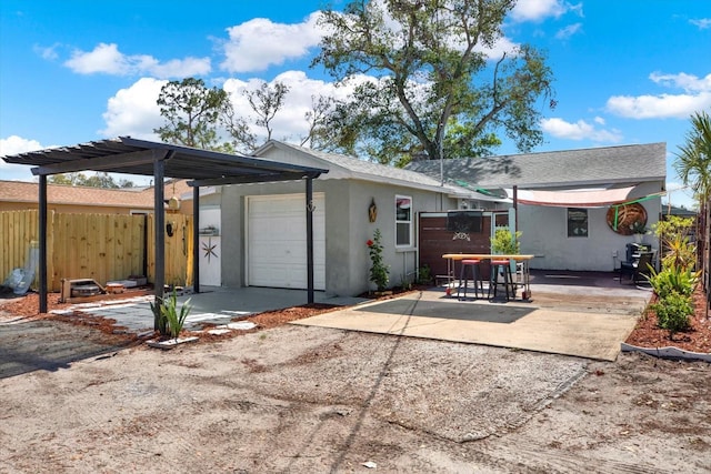 back of property with stucco siding, a patio, an attached garage, and fence