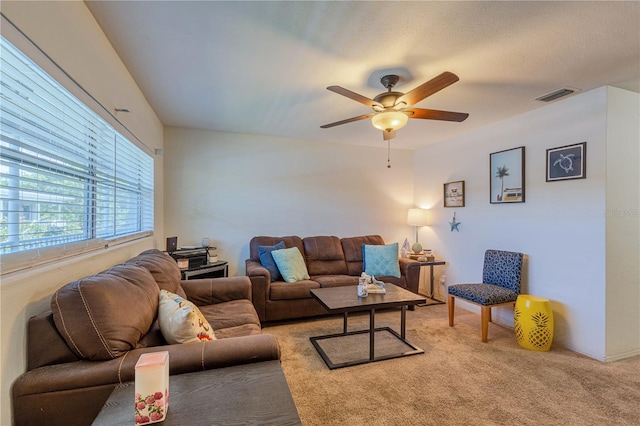 living room with visible vents, light colored carpet, and ceiling fan