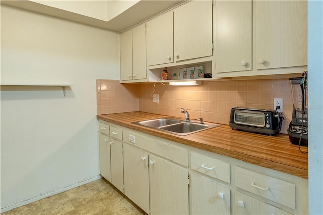 kitchen with open shelves, a toaster, backsplash, and a sink