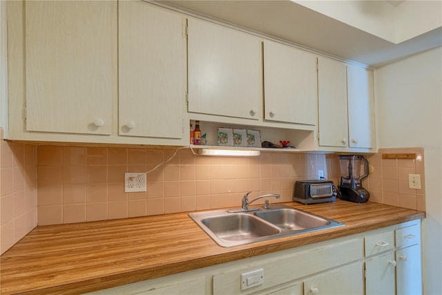 kitchen featuring decorative backsplash, open shelves, light countertops, and a sink