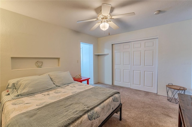 bedroom with a closet, carpet flooring, baseboards, and ceiling fan