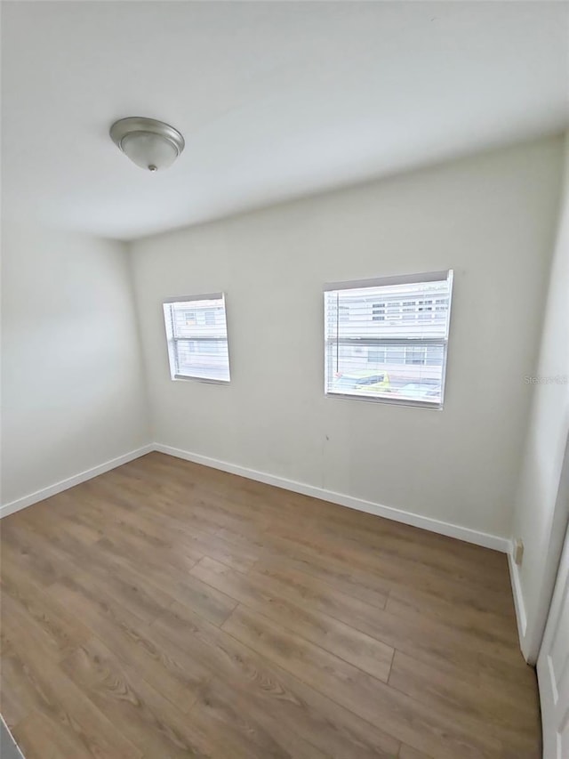 empty room featuring baseboards and wood finished floors