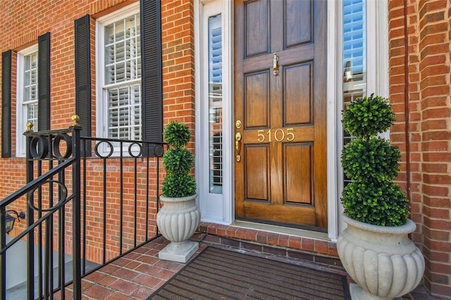 doorway to property with brick siding