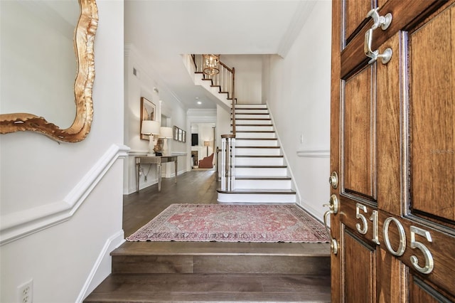 foyer entrance with stairway, crown molding, and baseboards