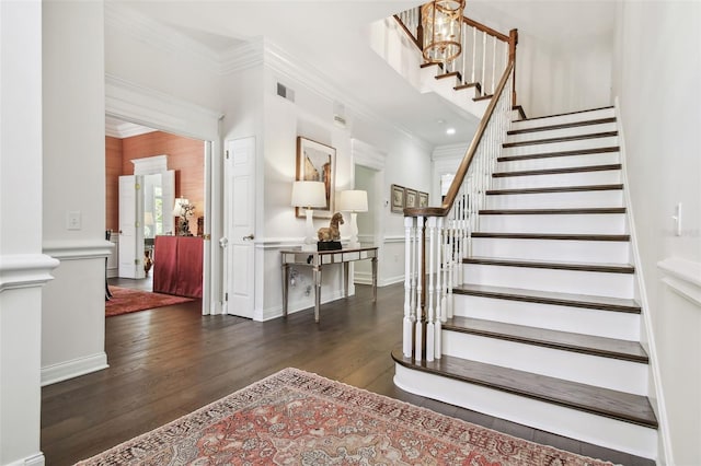 staircase with visible vents, baseboards, ornamental molding, and hardwood / wood-style flooring