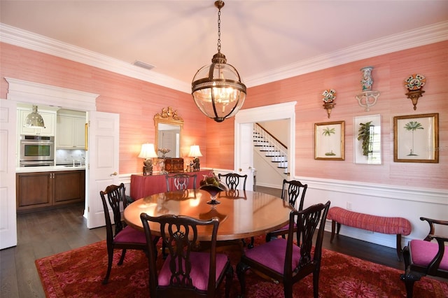 dining area featuring visible vents, dark wood-style flooring, stairs, crown molding, and a chandelier