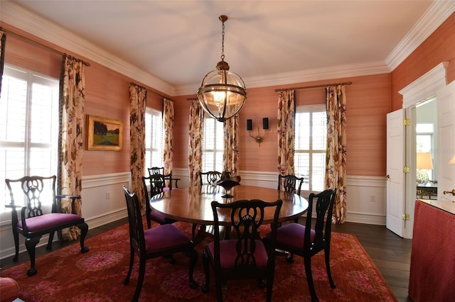 dining area with dark wood-type flooring, a healthy amount of sunlight, ornamental molding, and wainscoting