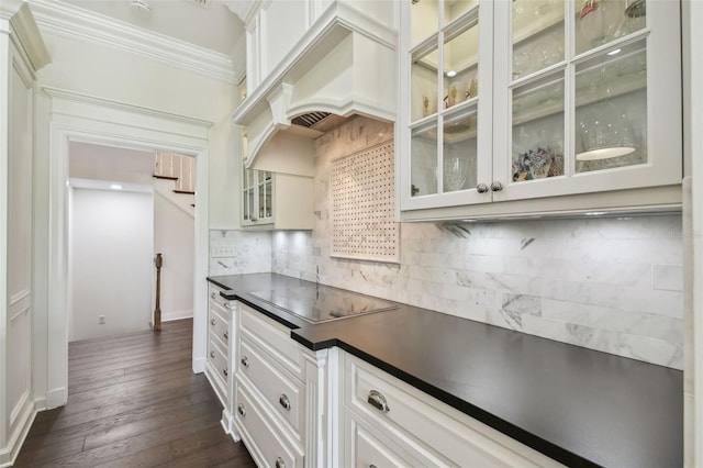 kitchen with ornamental molding, tasteful backsplash, dark countertops, black electric cooktop, and custom exhaust hood