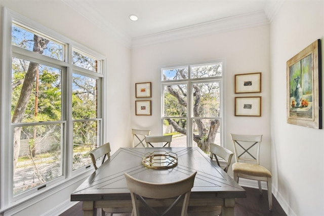 dining room featuring crown molding, wood finished floors, and baseboards