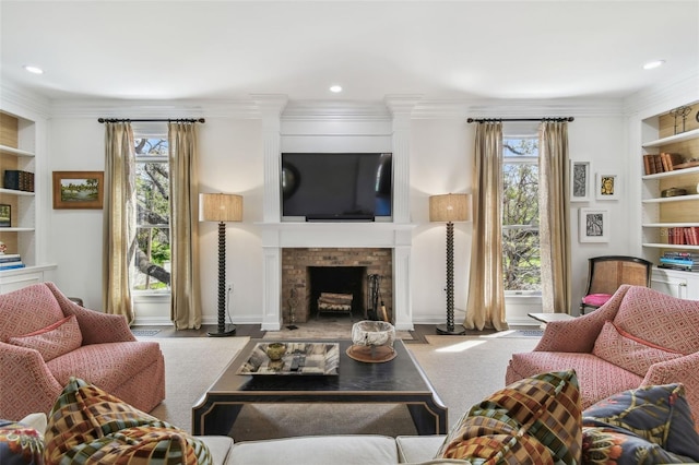 living room featuring built in shelves, a fireplace, recessed lighting, and ornamental molding