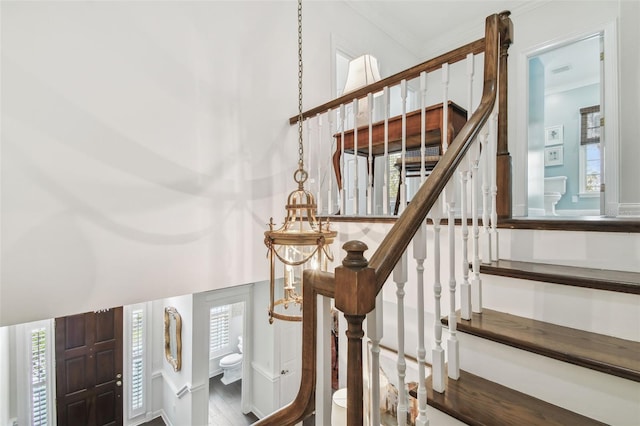 staircase with a high ceiling and ornamental molding