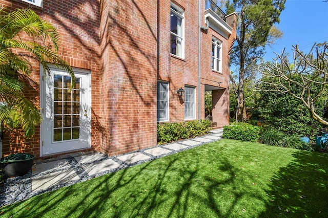 view of home's exterior featuring a yard and brick siding