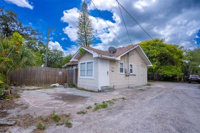 view of side of home with driveway and fence