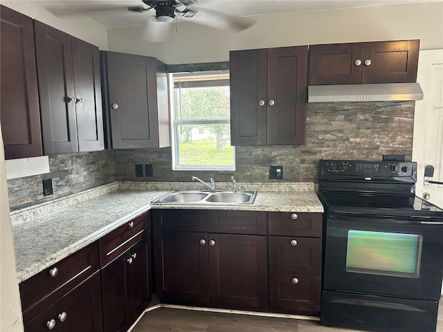 kitchen with under cabinet range hood, a sink, light countertops, and black electric range