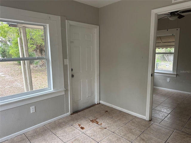 foyer featuring a wealth of natural light, baseboards, and a ceiling fan