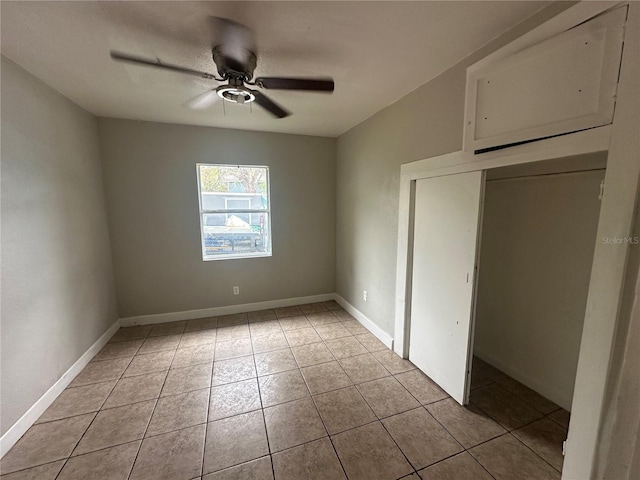 unfurnished bedroom with light tile patterned floors, baseboards, and ceiling fan