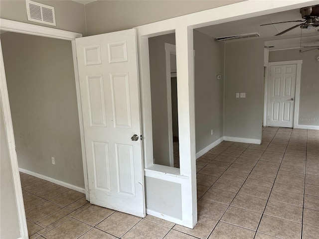 interior space featuring light tile patterned floors, visible vents, baseboards, and a ceiling fan