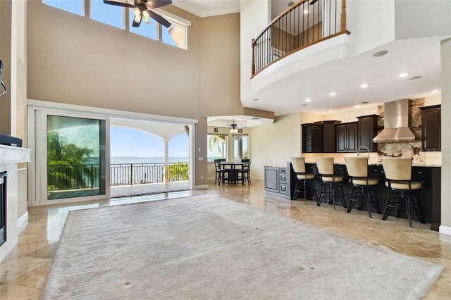 living area with marble finish floor, a healthy amount of sunlight, and a ceiling fan