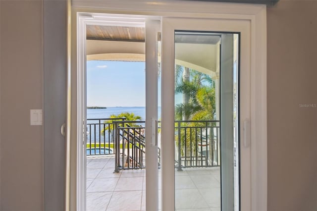 entryway with tile patterned flooring and a water view
