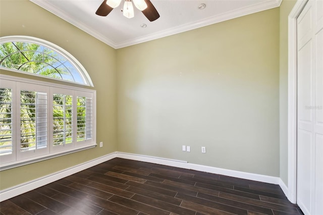 spare room with crown molding, a ceiling fan, dark wood-type flooring, and baseboards