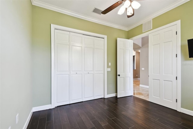 unfurnished bedroom with dark wood finished floors, visible vents, arched walkways, and ornamental molding