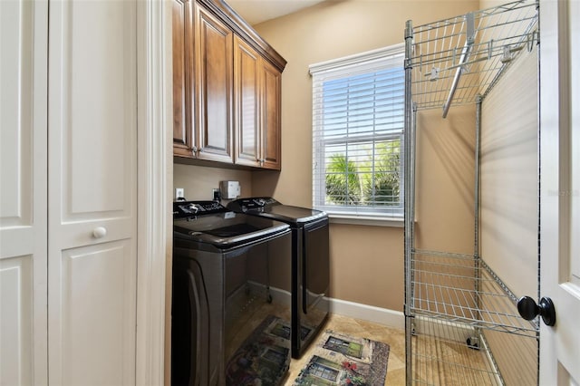 laundry area with cabinet space, tile patterned flooring, independent washer and dryer, and baseboards