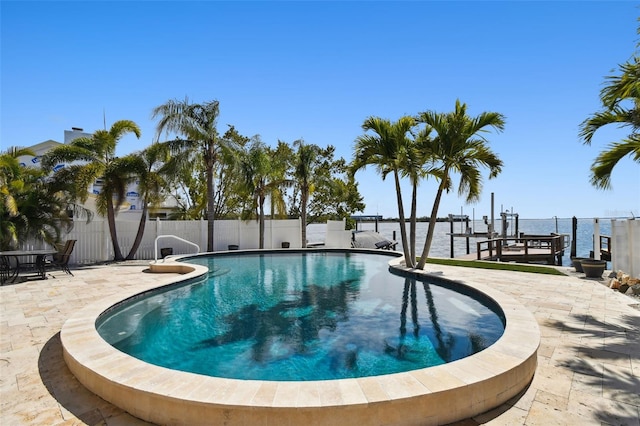 view of pool with a patio, fence, a fenced in pool, and a boat dock