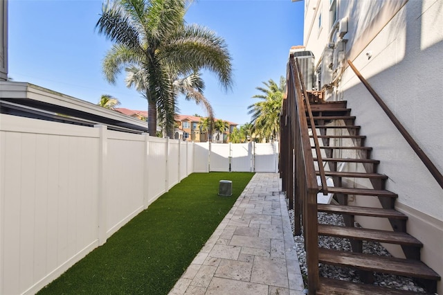 view of yard with stairs and a fenced backyard