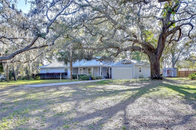 single story home with a shed, an outdoor structure, a front yard, and fence