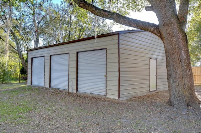 detached garage featuring fence