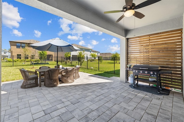 view of patio featuring area for grilling, outdoor dining space, fence, a residential view, and ceiling fan