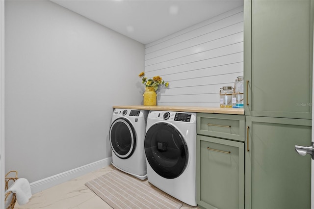 laundry room with cabinet space, washing machine and dryer, marble finish floor, and baseboards