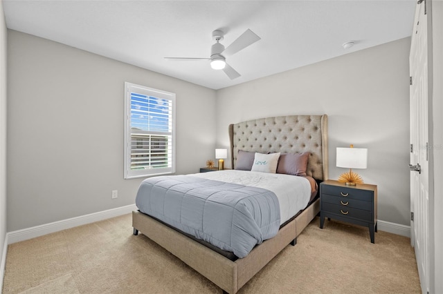 bedroom with light colored carpet, baseboards, and ceiling fan