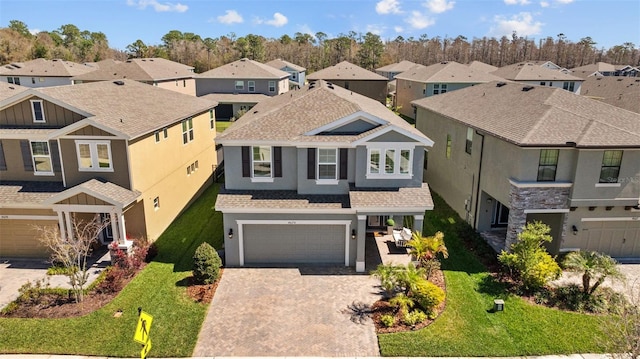 view of front of property featuring a residential view, an attached garage, and decorative driveway