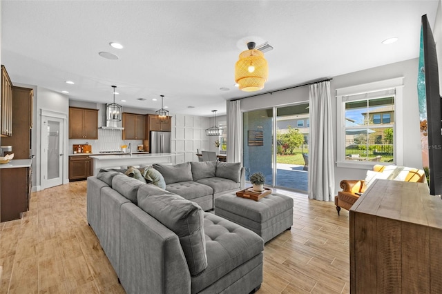 living room featuring recessed lighting, visible vents, and light wood finished floors