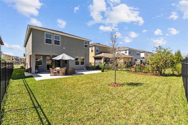 back of property featuring a fenced backyard, a residential view, stucco siding, a patio area, and a lawn