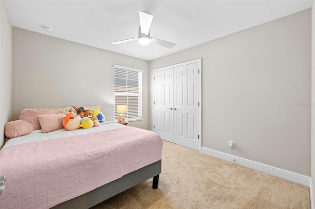 carpeted bedroom with a closet, ceiling fan, and baseboards