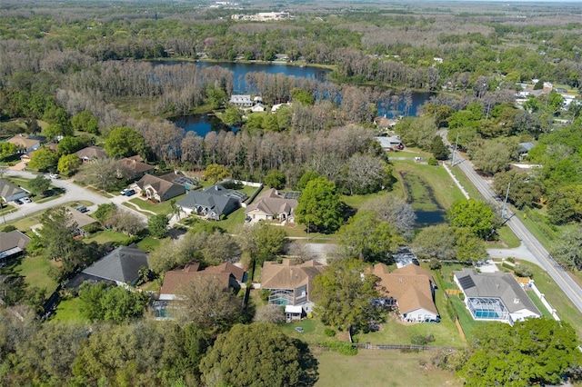 aerial view with a forest view, a water view, and a residential view