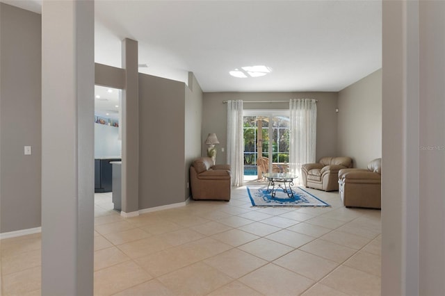 living area featuring light tile patterned floors and baseboards