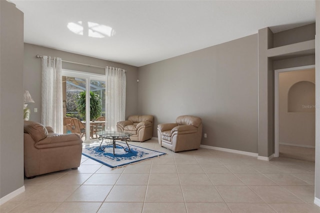 living area featuring baseboards and light tile patterned flooring