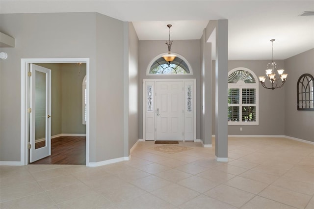 foyer featuring light tile patterned flooring, visible vents, baseboards, and an inviting chandelier