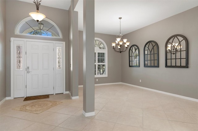 entrance foyer with a notable chandelier, baseboards, and light tile patterned floors