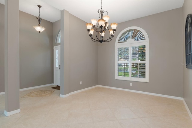 empty room with a notable chandelier and baseboards