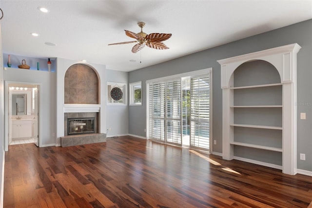 unfurnished living room with wood finished floors, recessed lighting, baseboards, ceiling fan, and a tile fireplace