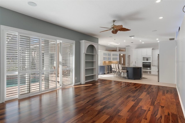 unfurnished living room with visible vents, ceiling fan, recessed lighting, wood finished floors, and a sink