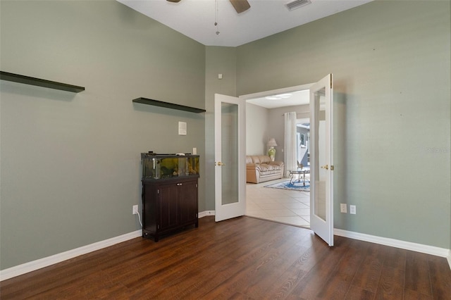 empty room featuring visible vents, baseboards, french doors, wood finished floors, and a ceiling fan