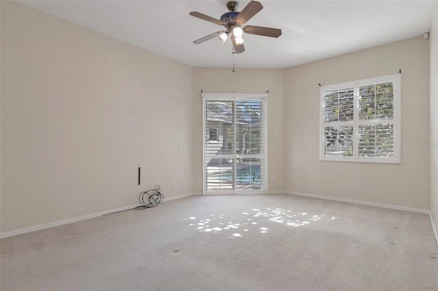 spare room featuring a ceiling fan, baseboards, and carpet floors